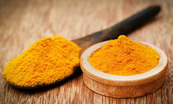 Ground turmeric in a spoon and bowl — Stock Photo, Image