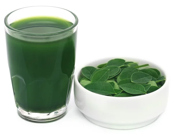 Hojas de moringa con extracto en un vaso — Foto de Stock