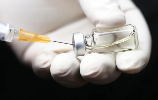 Mano sosteniendo una jeringa con vial — Foto de Stock