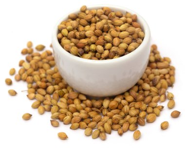 Beyaz arka planda bir kasede kişniş.