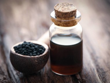 Nigella tohumları ve cam bir şişede gerekli yağ