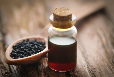 Nigella tohumları ve cam bir şişede gerekli yağ