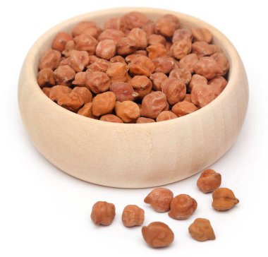 Beyaz arka planda bir kasede çiğ nohut.