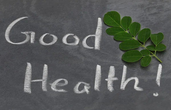 Moringa leaves with Good Health written in a slate — Stock Photo, Image