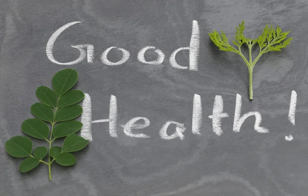 Moringa leaves with Good Health written in a slate — Stock Photo, Image