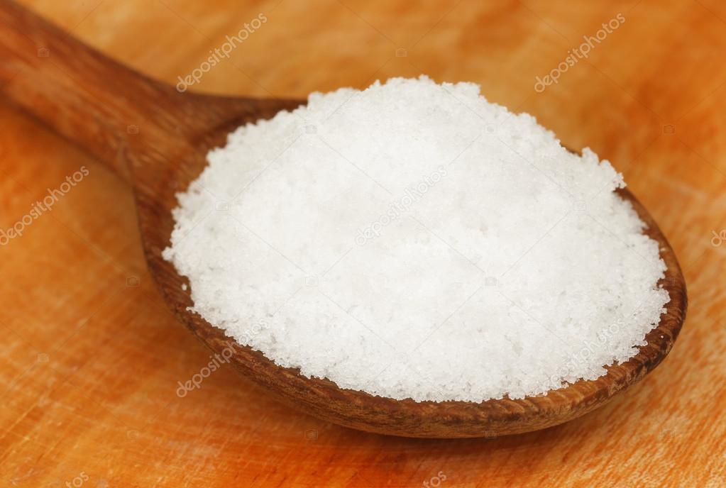 Table salt on wooden spoon