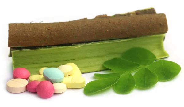 Moringa leaves and bark with pills — Stock Photo, Image