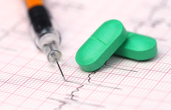 Electrocardiograma con pastillas y jeringa — Foto de Stock