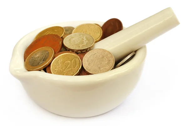 Coins in a mortar with pestle — Stock Photo, Image