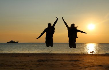İki genç kız plajda atlama