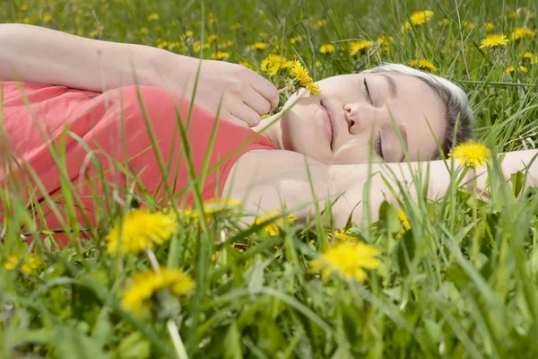 Kobieta leżąc na łące kwiat — Zdjęcie stockowe