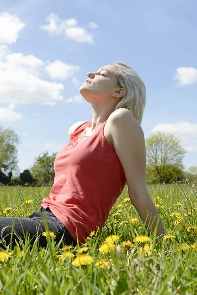 Donna seduta sul prato di fiori — Foto Stock