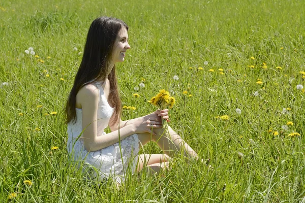 Vrouw met paardebloemen — Stockfoto