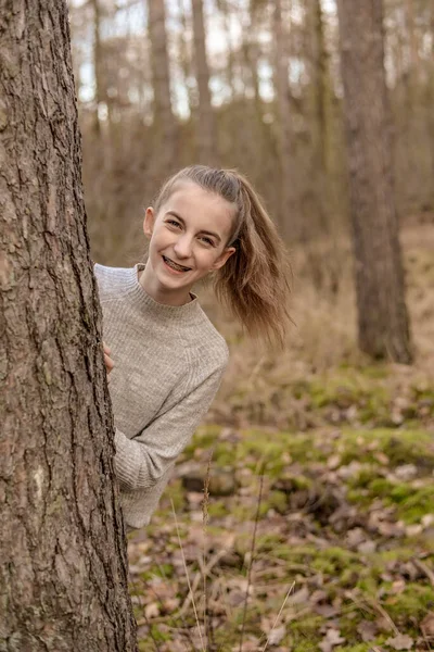 Szczęśliwa Młoda Dziewczyna Klamrą Stojąca Drzewie — Zdjęcie stockowe