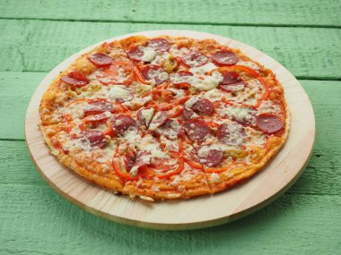 Tahta yeşil arka planda pizza. İtalyan mutfağı