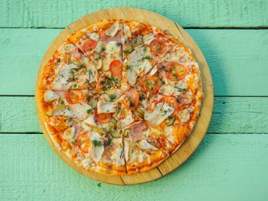 Tahta yeşil arka planda pizza. İtalyan mutfağı