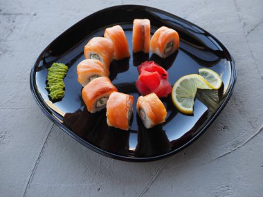 Japon mutfağı. Gri beton arka planda suşi ve rulo