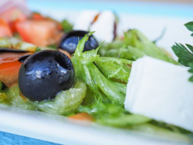 Mavi ahşap arka planda salatalık ve domates salatası.