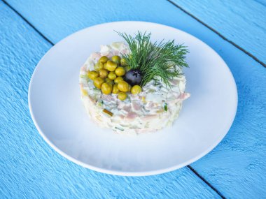 Mavi ahşap arka planda Olivier salatası