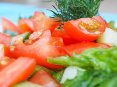 Mavi ahşap arka planda salatalık ve domates salatası.