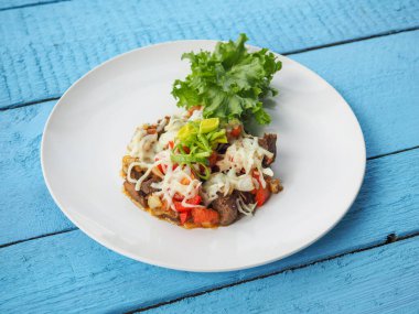 Mavi ahşap arka planda et salatası