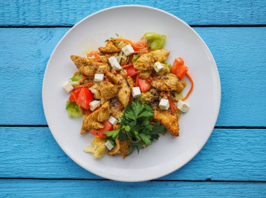 Mavi ahşap arka planda tavuk salatası