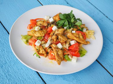 Mavi ahşap arka planda tavuk salatası