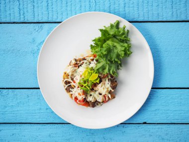 Mavi ahşap arka planda et salatası