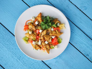 Mavi ahşap arka planda tavuk salatası