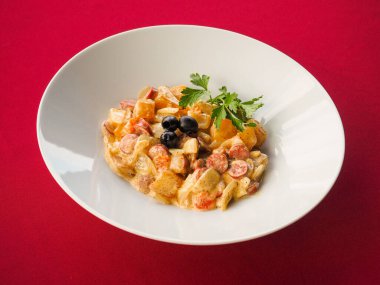 Kırmızı arka planda sosis salatası