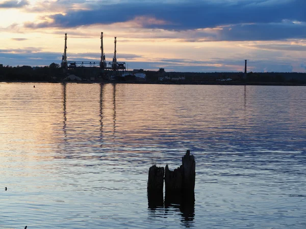 在日落时的湖岸上一个工业城市 — 图库照片