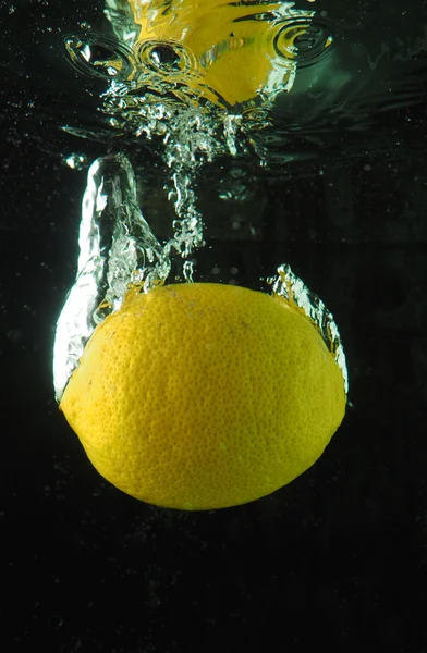 Lemon in the bubbles on a dark background — Stock Photo, Image