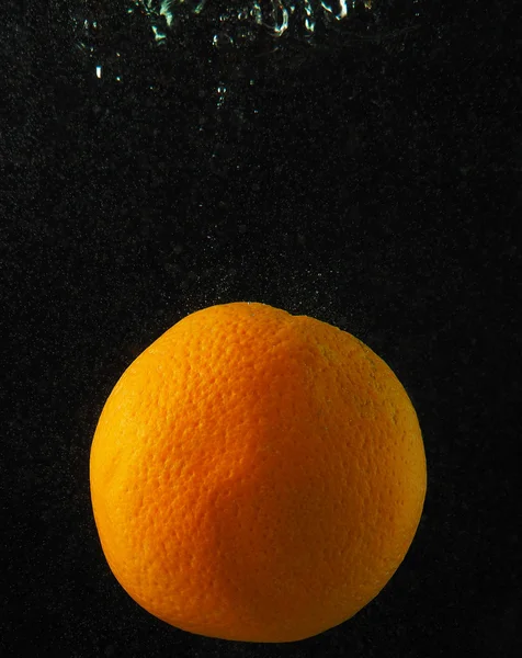 Naranja en agua con burbujas sobre fondo oscuro —  Fotos de Stock