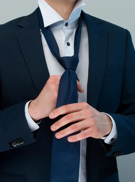 Businessman dressed up the knot of his cravat. — Stock Photo, Image