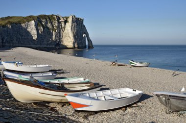 Small boats on pebble beach of Etretat in France
