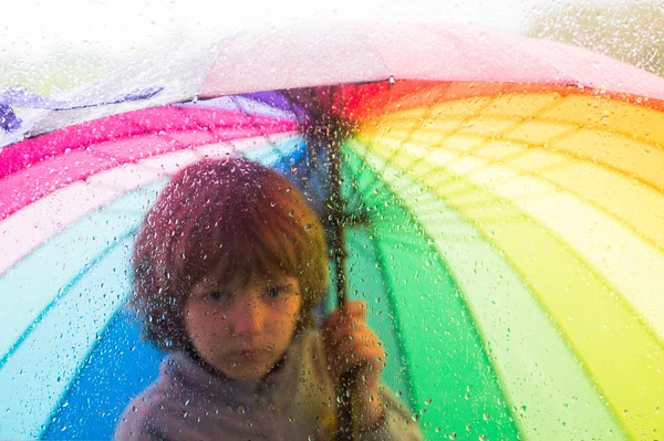 Bir şemsiye yağmur damla ile camın çocukla