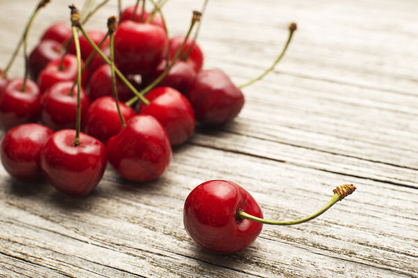 Cherry on wooden background close up.