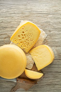 Kırsal ahşap masada çeşitli peynir türleri. Üst Manzara. Metin için boş alan.