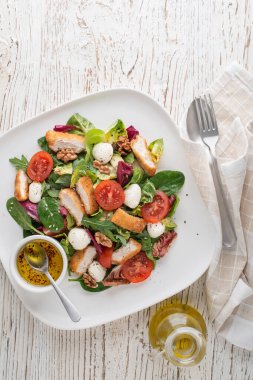 Kızarmış tavuk, peynir ve domatesli sağlıklı salata.