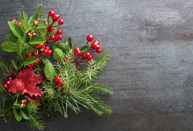 Noel süslemeleri ladin, ardıç ve kutsal kırmızı meyvelerin koyu arkaplanından.
