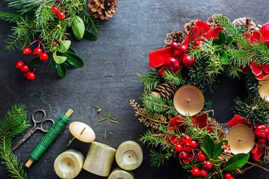 Ladin, ardıç ve kutsal kırmızı böğürtlenlerden çelenk yapmak. Evde Noel çelengi için süslemeler