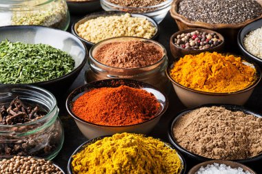Yemek pişirmek için renkli otlar ve baharatlar. Hindistan ve Asya baharatlarını yakın plan bardaklarda