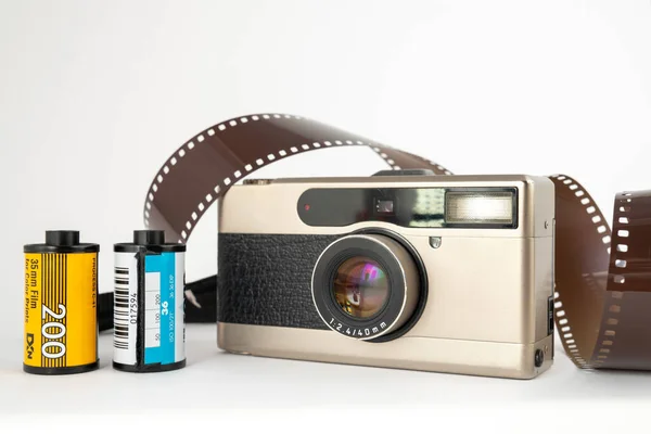 白い背景にフィルムとリールが付いたフィルムカメラ — ストック写真