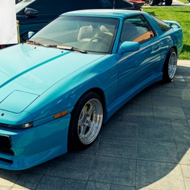 Parlak mavi spor spor bir coupe, özel akort, düşük süspansiyon, ve parlak krom alaşımlı tekerlekler, açık hava mekanında park