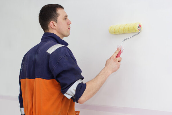 Young man with painting roller for walls