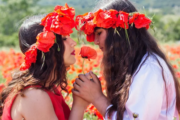 Two girl are holding poppy flower — Zdjęcie stockowe
