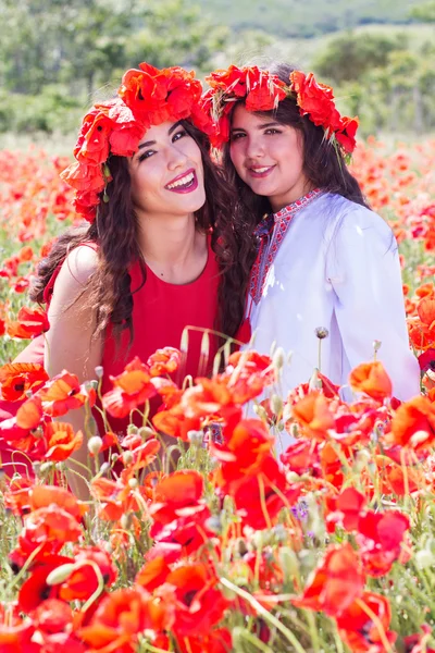 Two pretty girls in a field of poppy flowers — Stockfoto