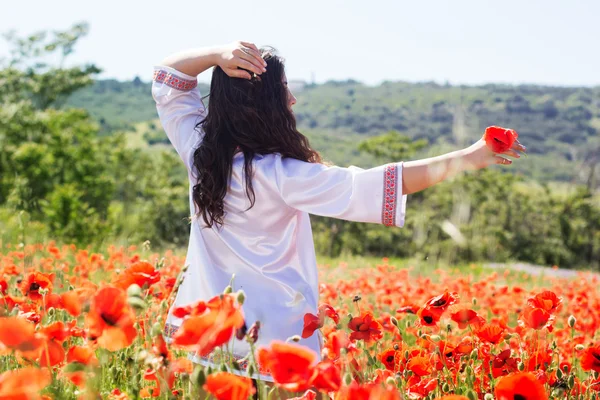 Beauté femme dans le champ rouge de coquelicots — Photo