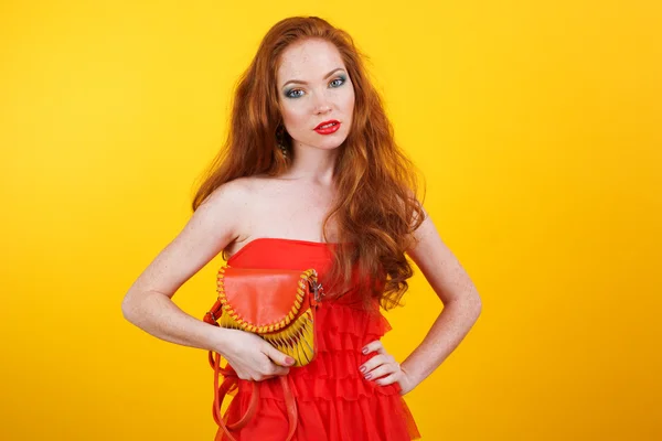 Redheaded pretty girl with orange handbag — Stockfoto
