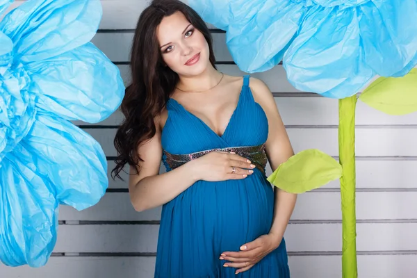 Ganska gravid flicka med stora blå blomma — Stockfoto